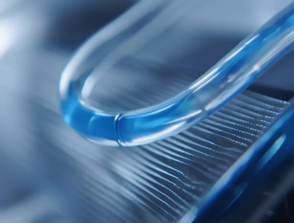Clear pipe with blue cooling liquid in front of a blurred background